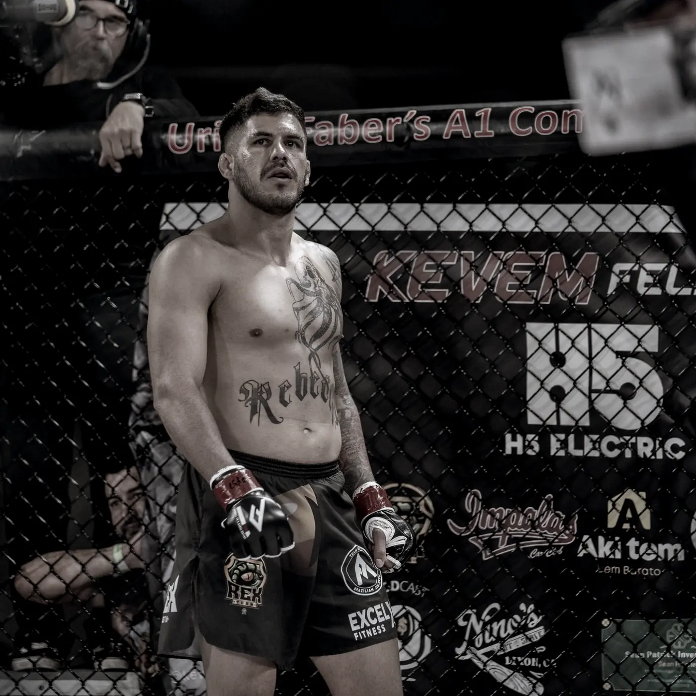 Kevem no cage diante da faixa KEVEM FELIPE com as marcas parceiras