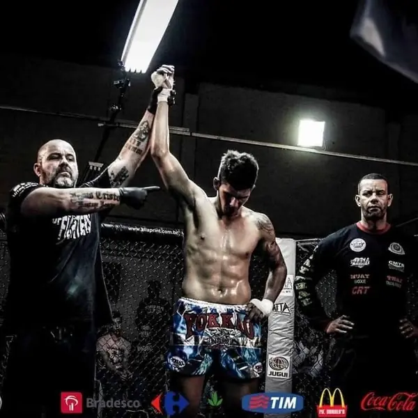 Kevem com o braço erguido depois de uma luta de muay thai