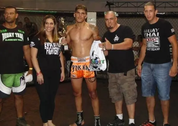Kevem com um troféu de muay thai, ao lado da equipe