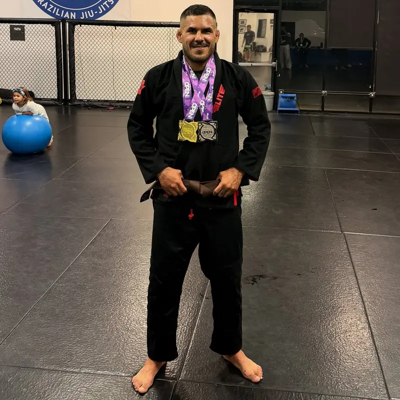 Kevem de kimono preto com as medalhas de jiu-jitsu