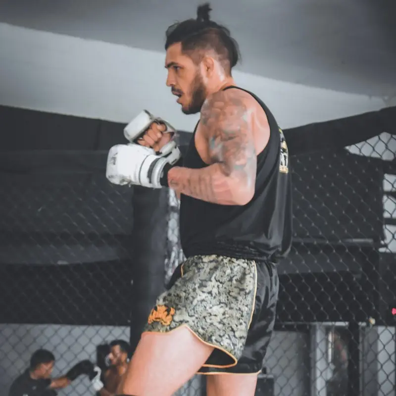Kevem throws punches in a tank top and Muay Thai shorts