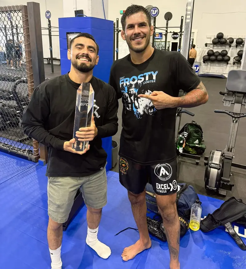 Kevem with a friend and a trophy at the gym