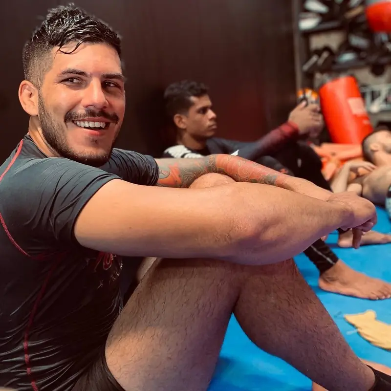 Kevem smiles, sitting on the mats
