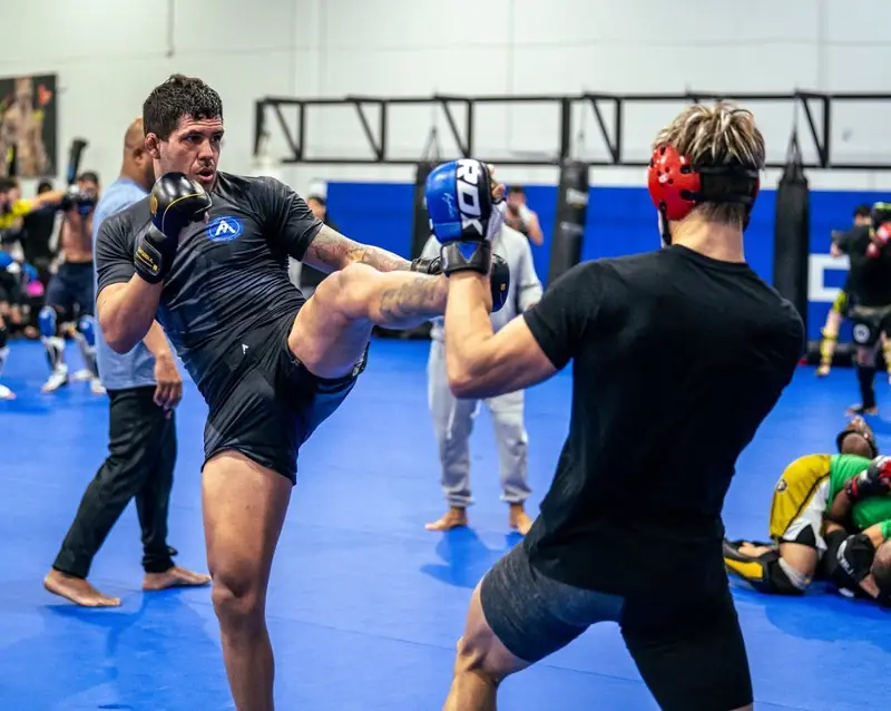 Kevem drills a kick on the pads with a partner
