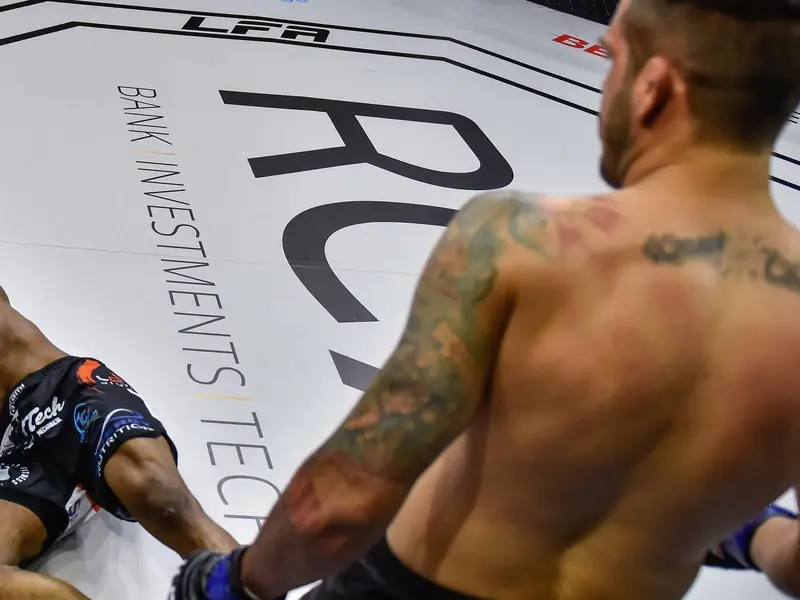 Kevem em pé no cage do LFA 152, com o adversário nocauteado no chão