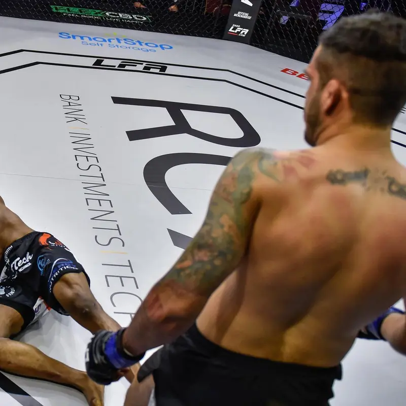 Kevem em pé no cage do LFA 152, com o adversário nocauteado no chão