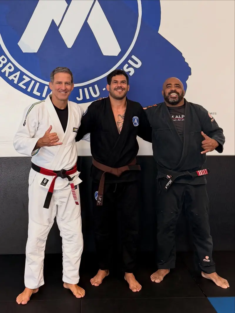 Kevem with jiu-jitsu coaches at the academy