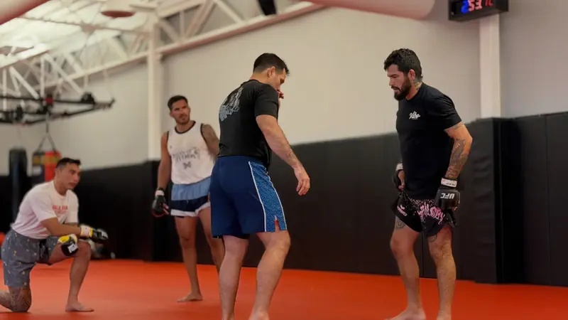 Kevem talks with the team on the mats