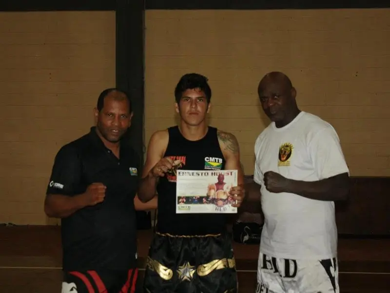 Kevem segura o certificado do curso ao lado de Ernesto Hoost